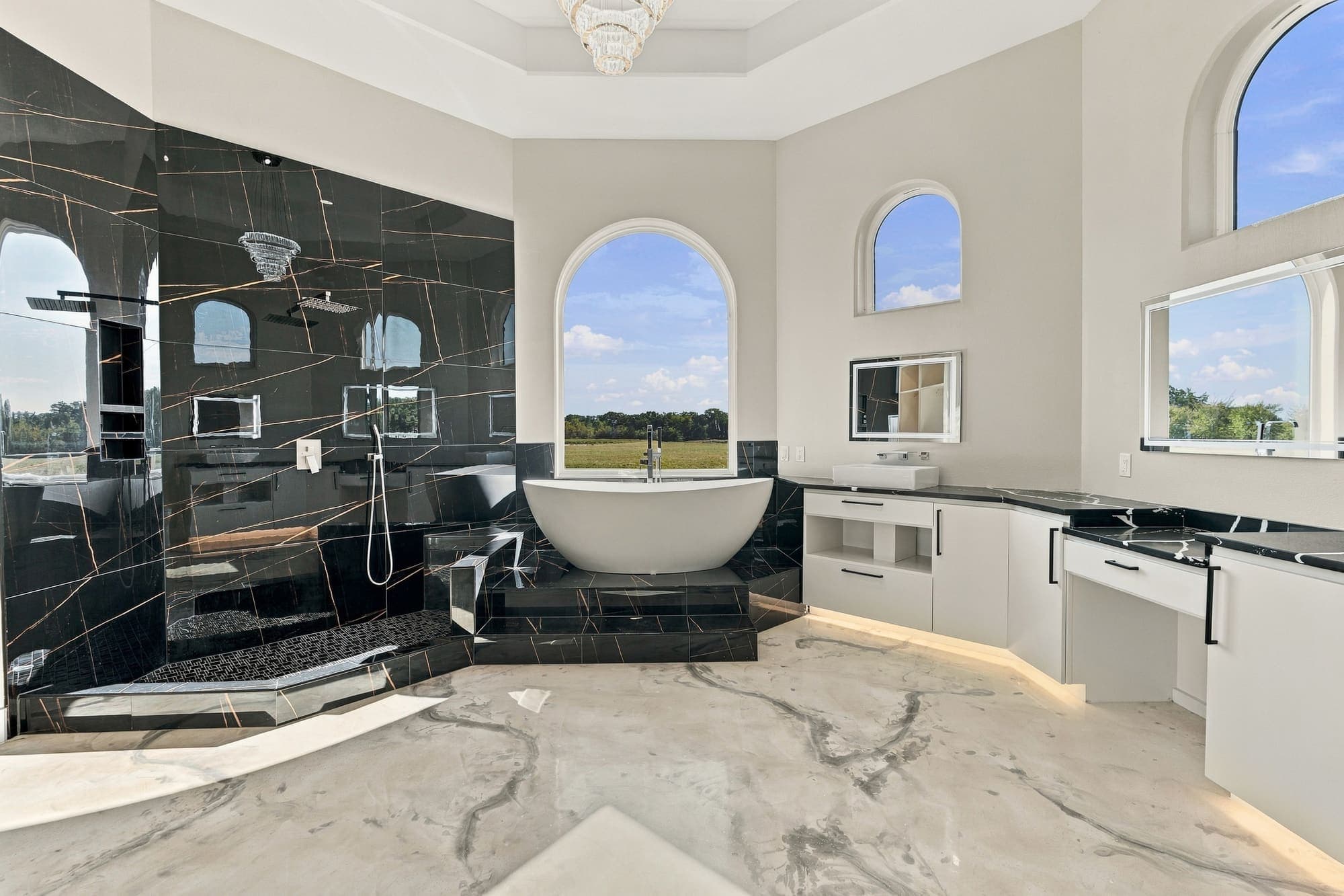 Primary bath with two-person soaking tub and black stone shower
